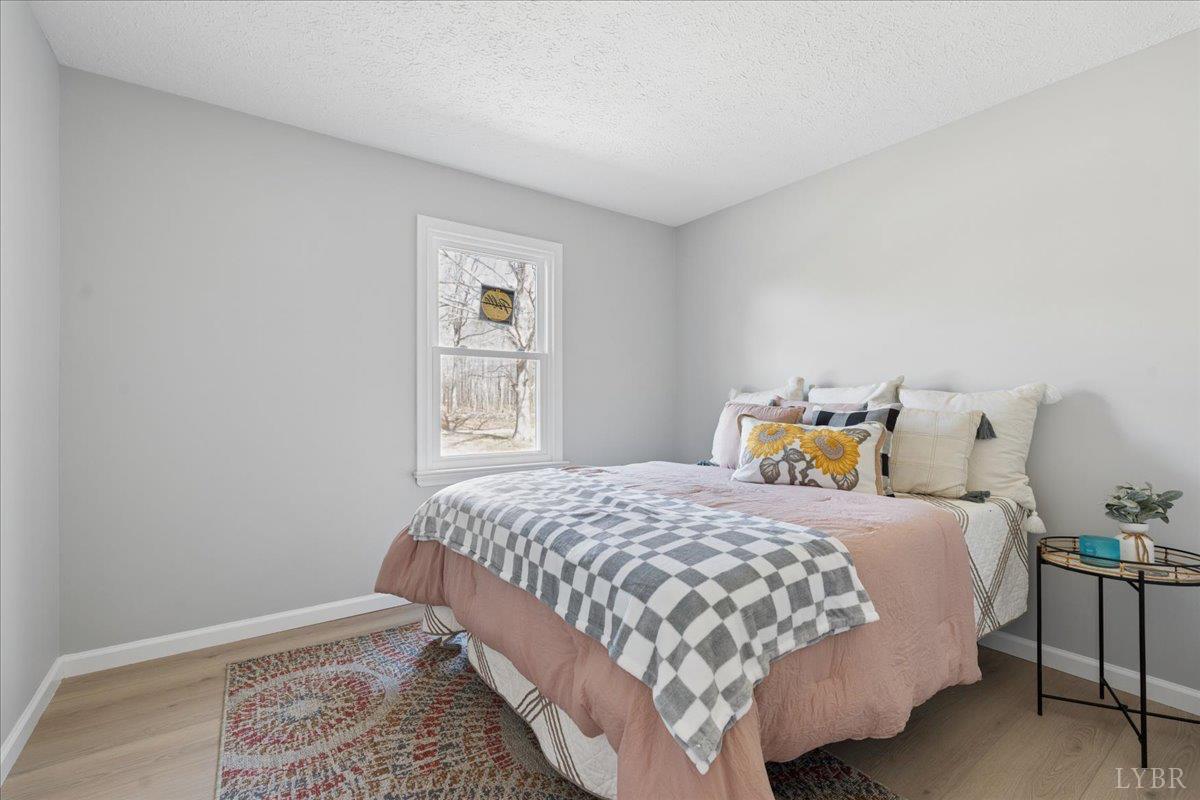 146 Watts Mill Road Pamplin, VA 23958 - Photo 14 of 37 a bedroom with a bed and wooden floor