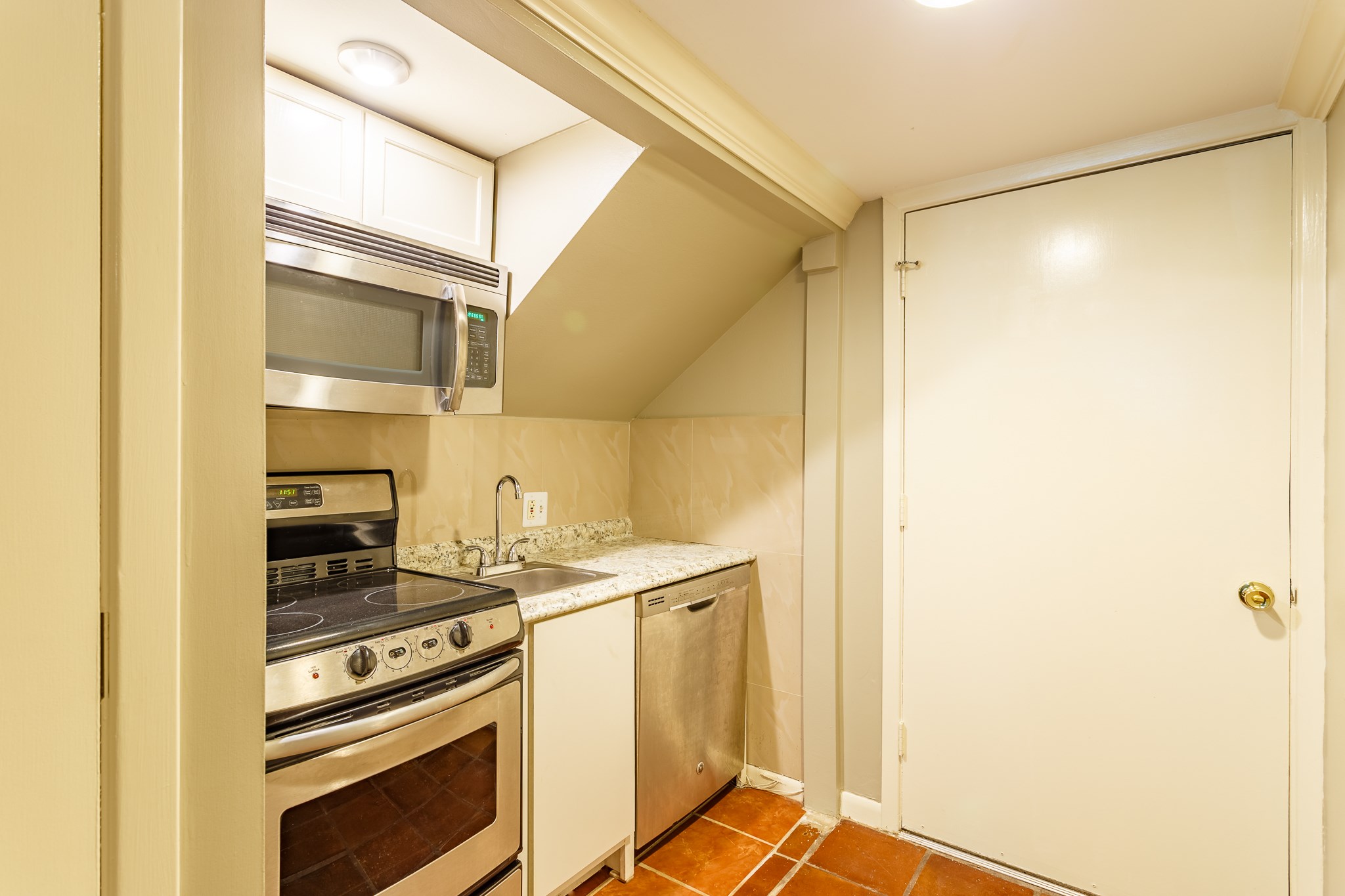 2349 Albans Road, Unit 1 Houston, TX 77005 - Photo 10 of 14 Kitchen featuring modern stainless steel appliances, including a stove, microwave, and dishwasher. Layout with granite countertops and sleek cabinetry, perfect for efficient cooking and easy maintenance.