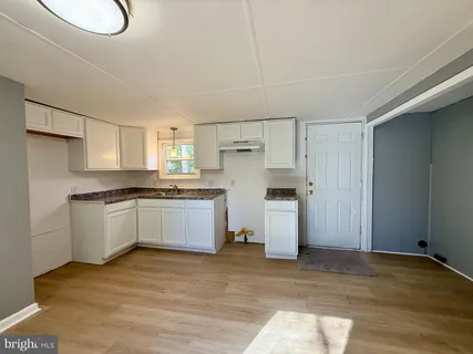 a kitchen with a refrigerator and white cabinets