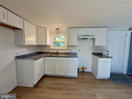 a kitchen with a sink cabinets and window