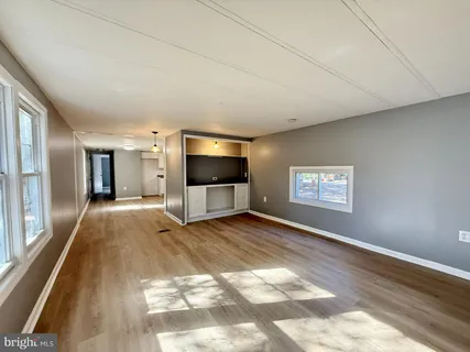 a view of a livingroom with wooden floor and flat screen tv