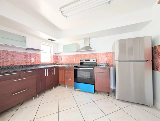 a kitchen with stainless steel appliances granite countertop a refrigerator and a stove