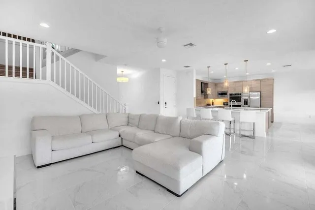 a living room with furniture and kitchen view