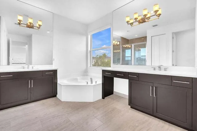 a bathroom with a sink vanity tub and a mirror