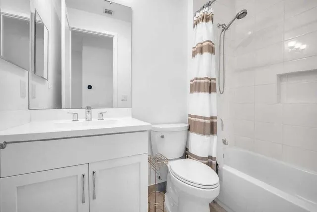 a bathroom with a sink toilet vanity and shower