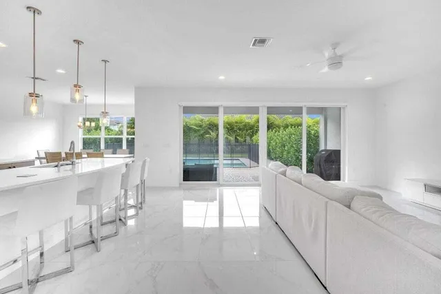 a large white kitchen with a large window and stainless steel appliances