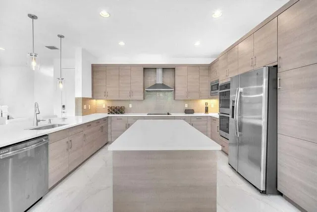 a large kitchen with kitchen island a sink stainless steel appliances and cabinets