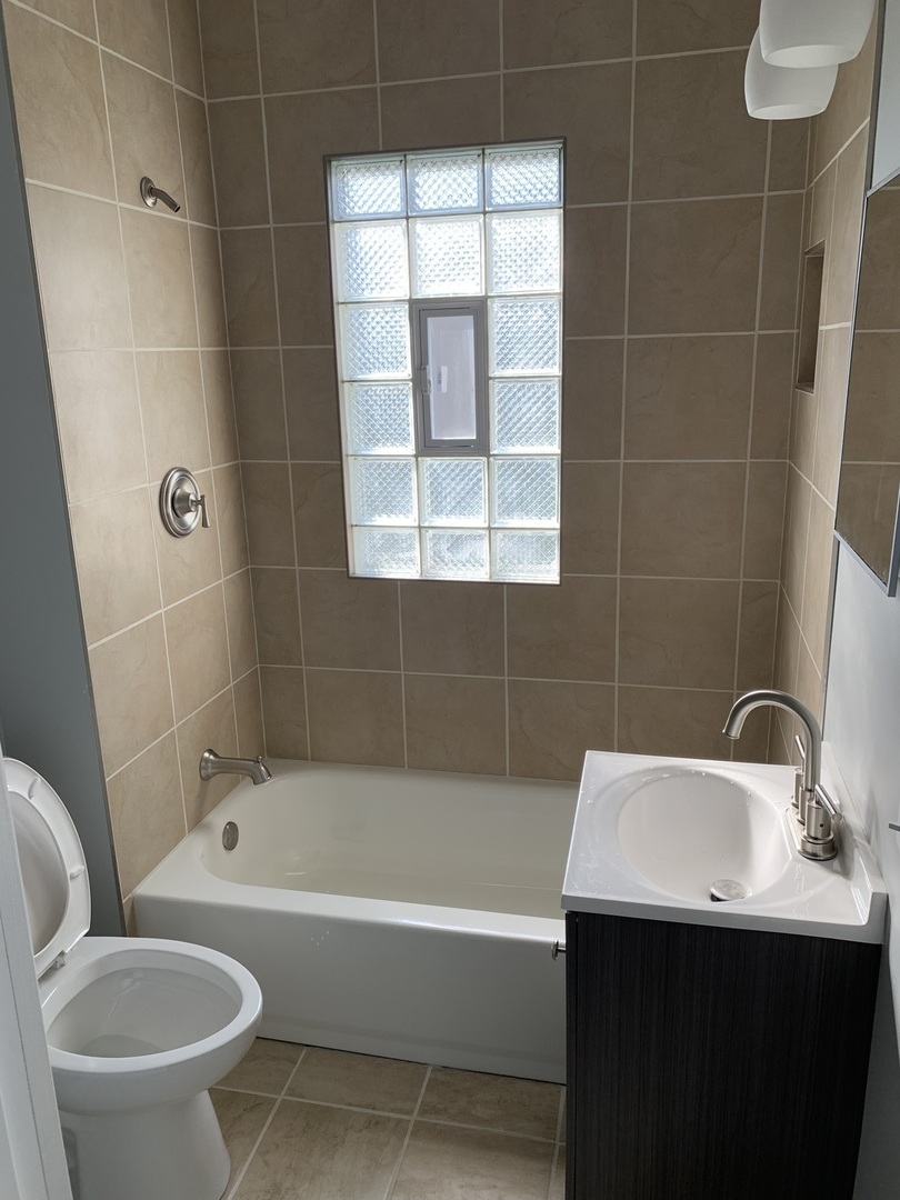 7555 West 63rd Place Summit, IL 60501 - Photo 12 of 19 a bathroom with a sink toilet and shower