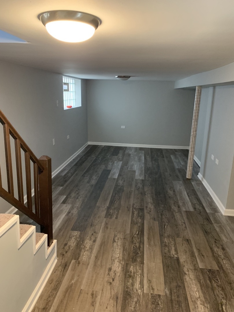 7555 West 63rd Place Summit, IL 60501 - Photo 14 of 19 wooden floor in an empty room with a window