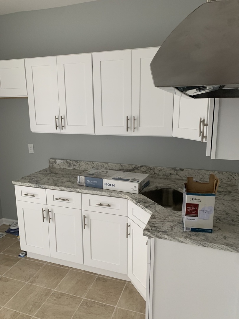 7555 West 63rd Place Summit, IL 60501 - Photo 8 of 19 a kitchen with granite countertop white cabinets and white appliances