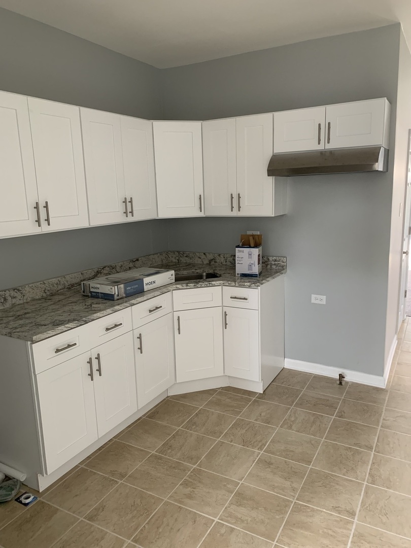7555 West 63rd Place Summit, IL 60501 - Photo 9 of 19 a kitchen with granite countertop white cabinets and white appliances