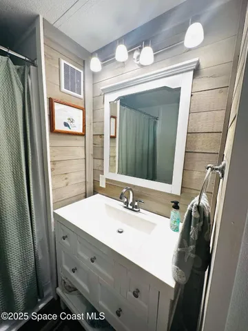a bathroom with a sink a mirror and a shower