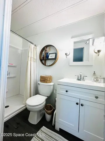 a bathroom with a toilet sink vanity and mirror