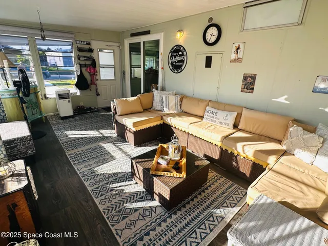 a living room with patio furniture and a rug