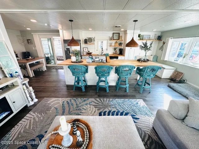 a living room with lots of furniture and view of kitchen
