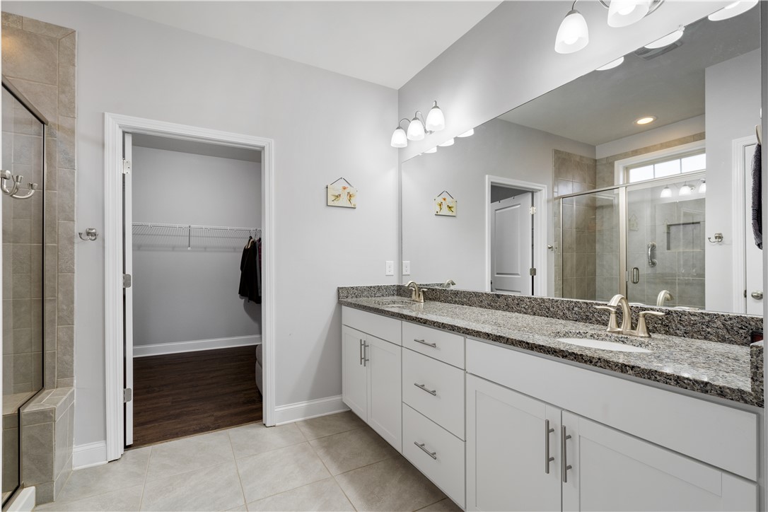 120 Rossmoor Court Anderson, SC 29621 - Photo 17 of 32 This spacious primary bathroom features a double vanity with granite counters and a glass-enclosed shower.