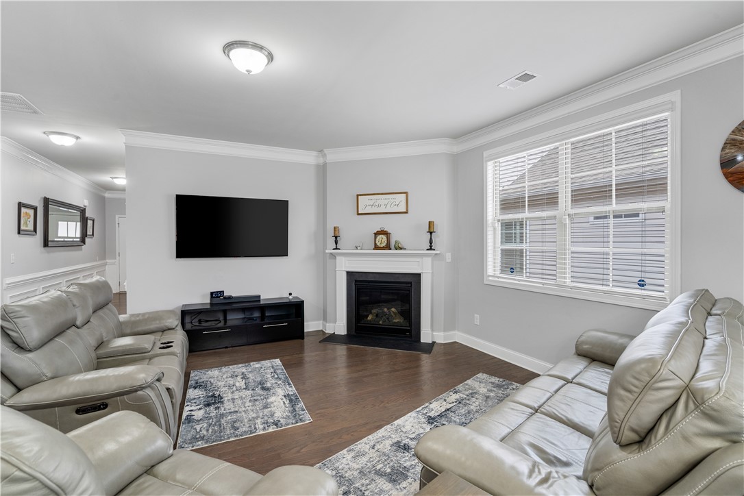 120 Rossmoor Court Anderson, SC 29621 - Photo 5 of 32 This inviting living space features rich hardwood floors and a cozy fireplace, perfect for gathering.