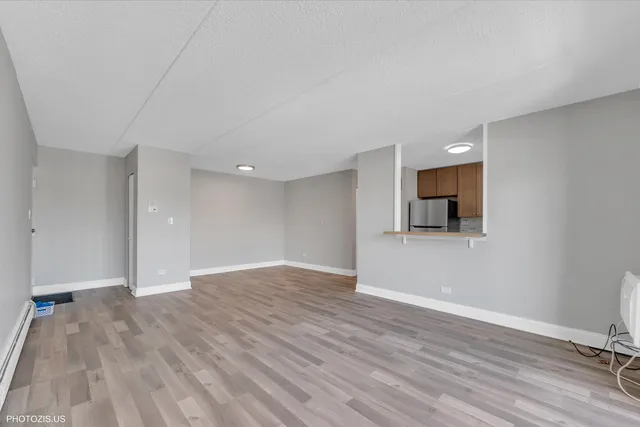 a view of empty room with wooden floor