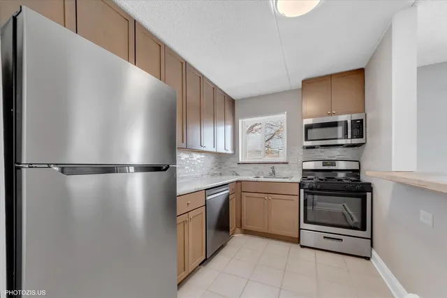 a kitchen with stainless steel appliances granite countertop a refrigerator and a sink