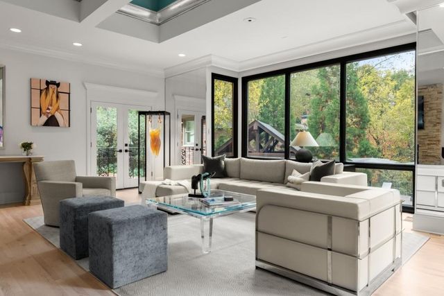 a kitchen with stainless steel appliances granite countertop a kitchen island a stove a refrigerator a oven a dining table and chairs with wooden floor