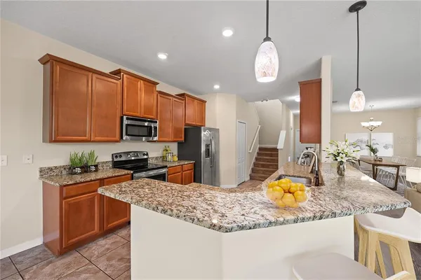 a kitchen with stainless steel appliances granite countertop a sink a stove and a wooden floors