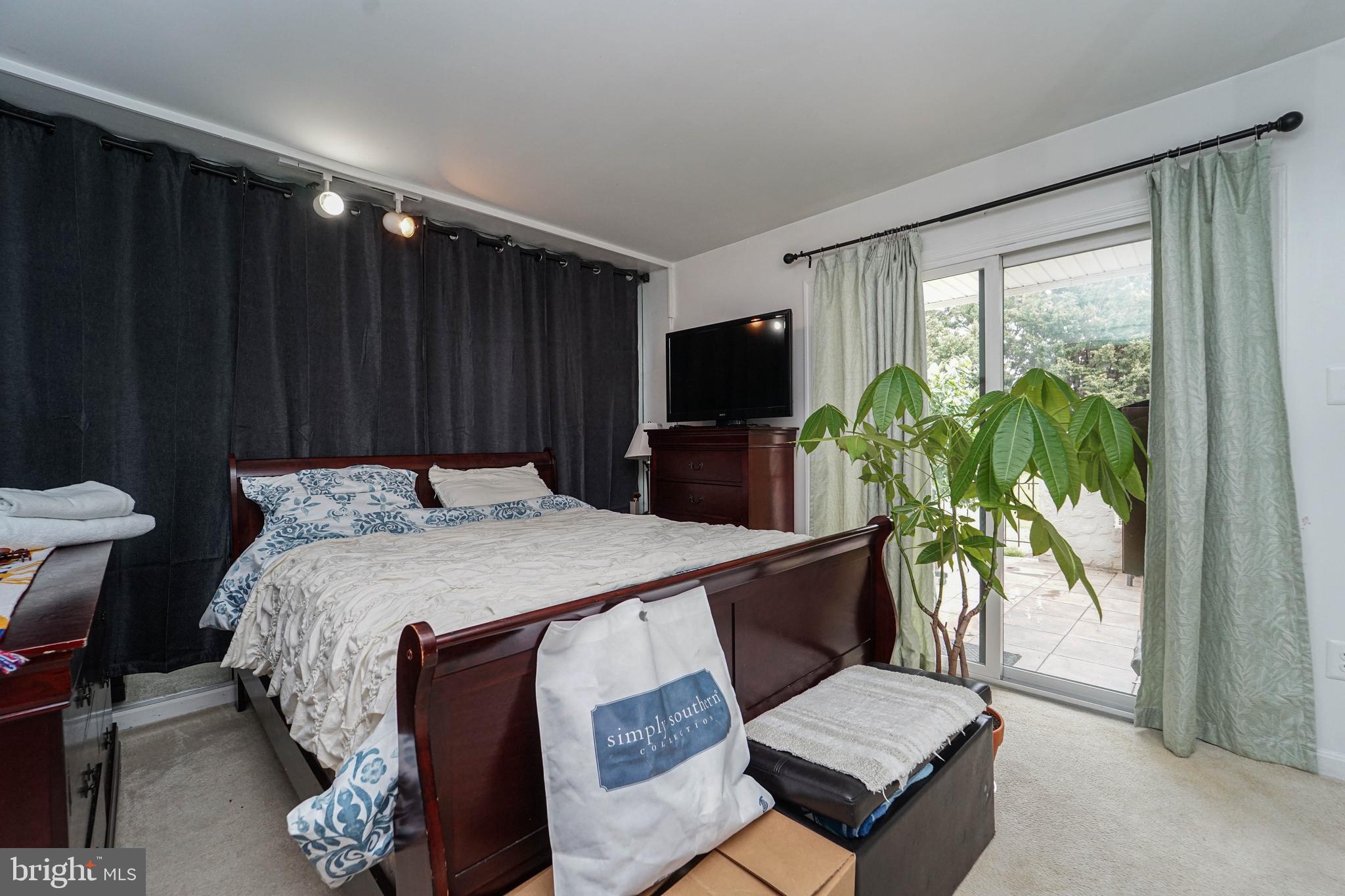8 Queen Victoria Way Chester, MD 21619 - Photo 26 of 30 a bed sitting in a bedroom next to a window with potted plants on a table