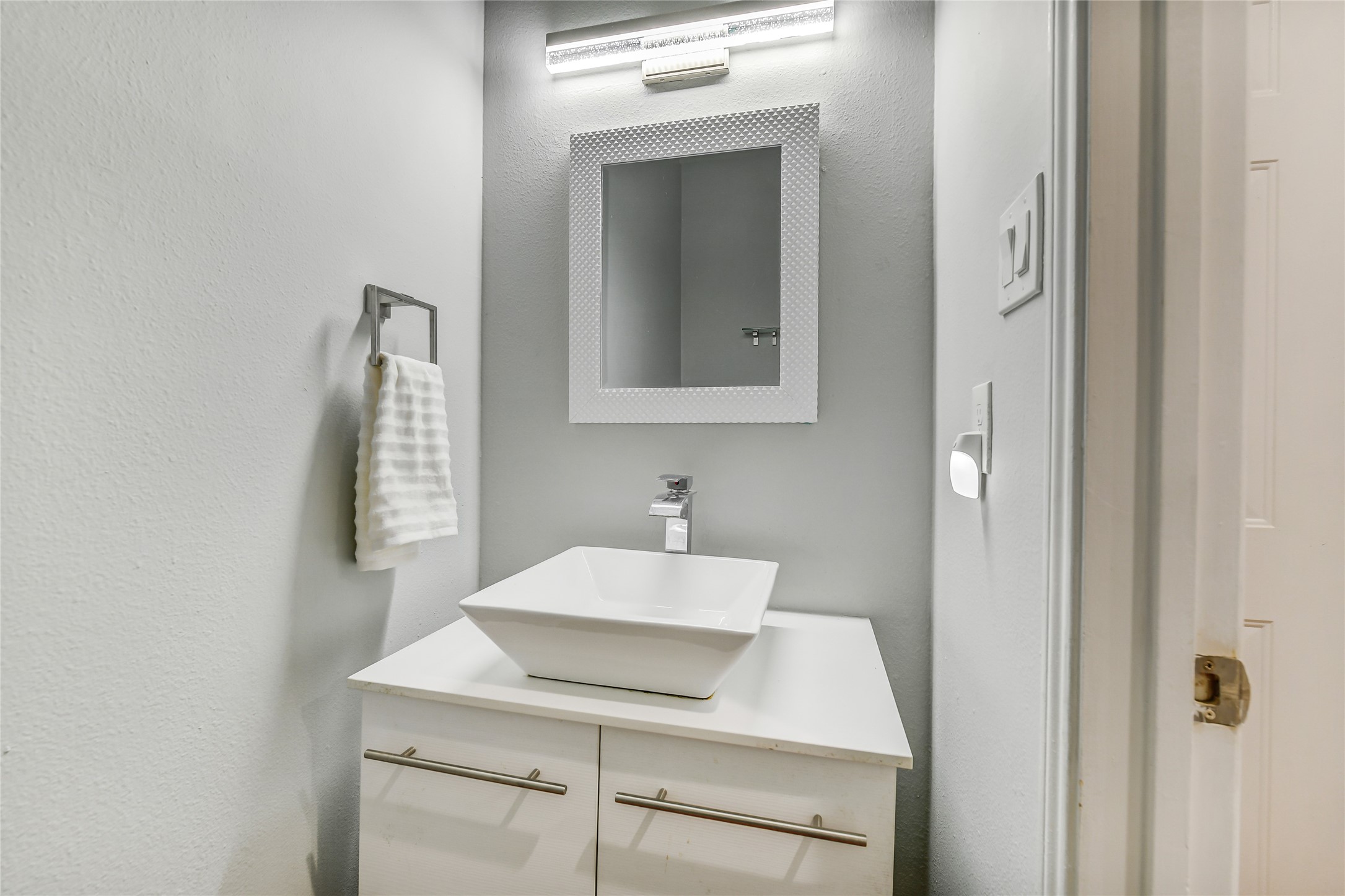 4001 Tanglewilde Street, Unit 1402 Houston, TX 77063 - Photo 7 of 23 Discover a sleek, updated half bath under the stairs for guests, paired with a spacious utility closet offering excellent storage solutions.