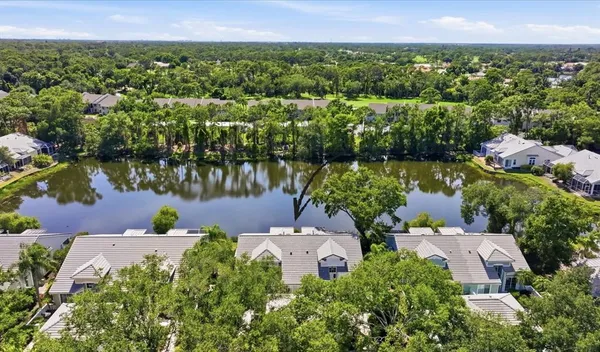 an aerial view of a house with a garden and lake view
