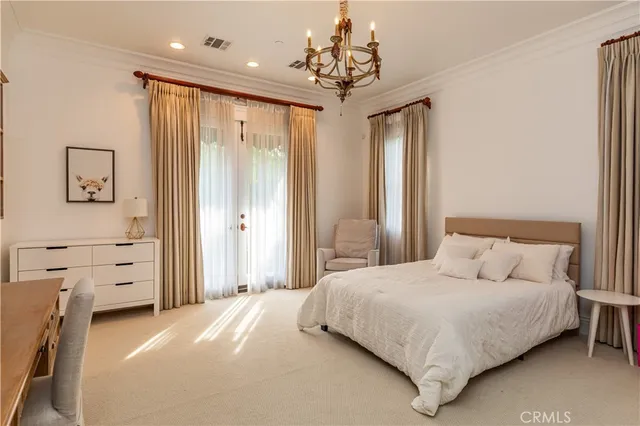 a bedroom with a bed and a chandelier