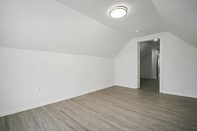 an empty room with wooden floor and mirror