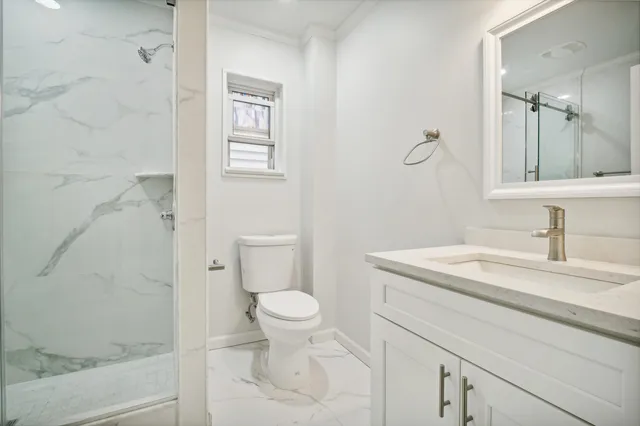 a bathroom with a sink a toilet and shower