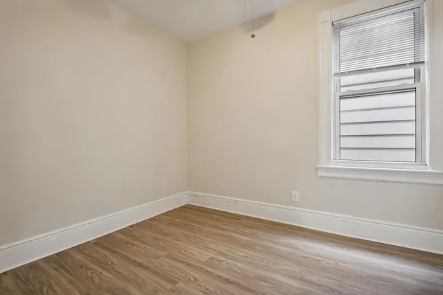 a view of a small space with wooden floor and a window