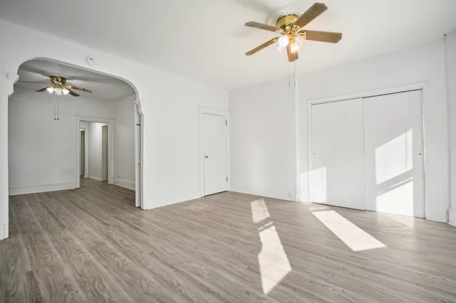a view of a room with wooden floor and a ceiling fan