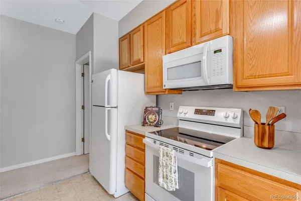 a kitchen with stainless steel appliances granite countertop a refrigerator a stove and a sink