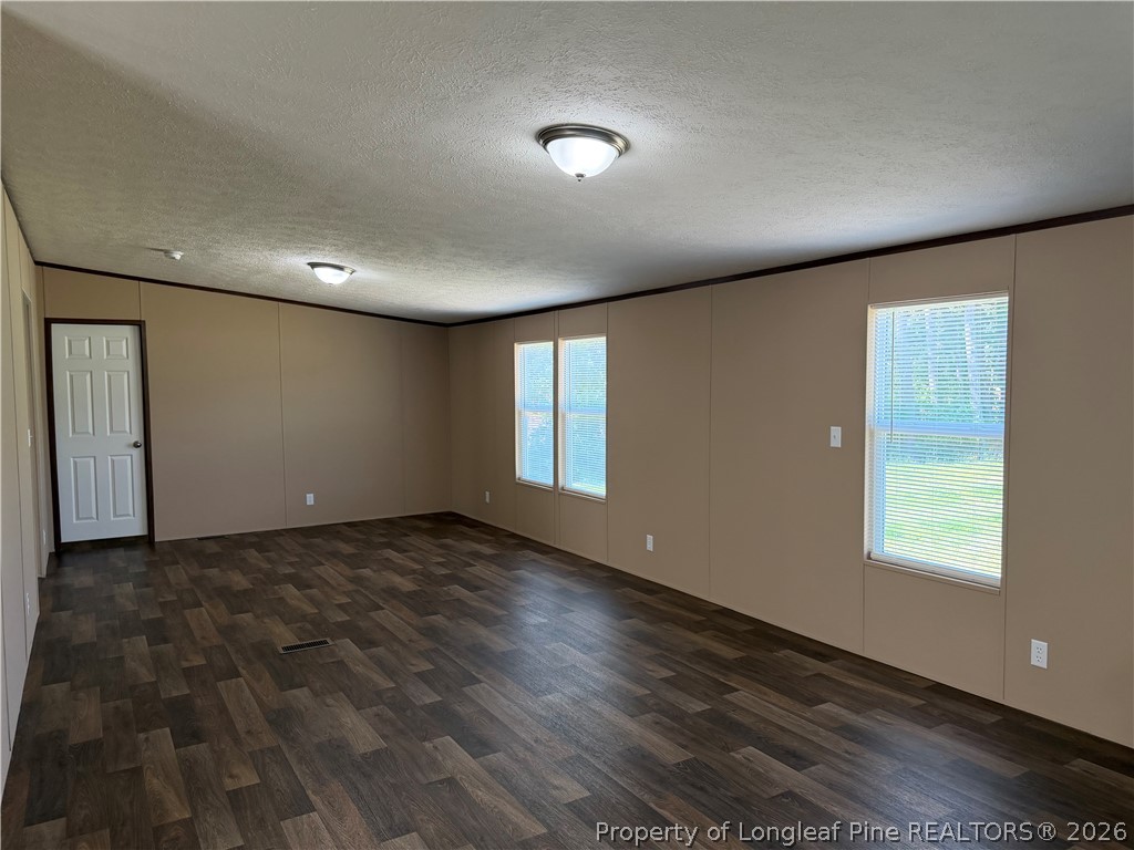 4339 Saddletree Road Lumberton, NC 28360 - Photo 11 of 23 an empty room with wooden floor and windows