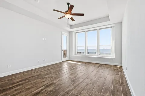 a view of a livingroom with wooden floor and a ceiling fan