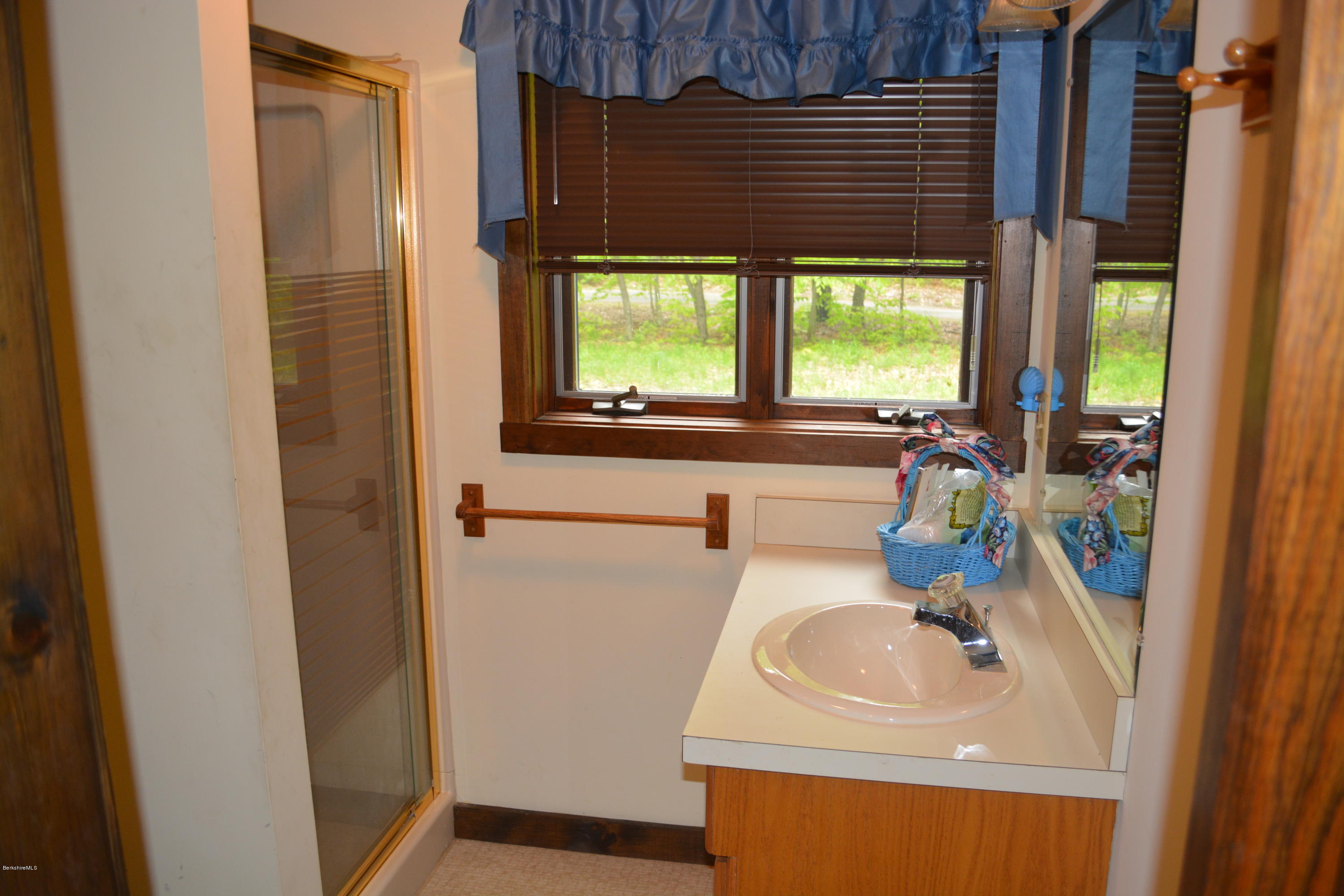 56 Slope Road Tolland, MA 01034 - Photo 13 of 52 a bathroom with a sink a mirror and next to a window