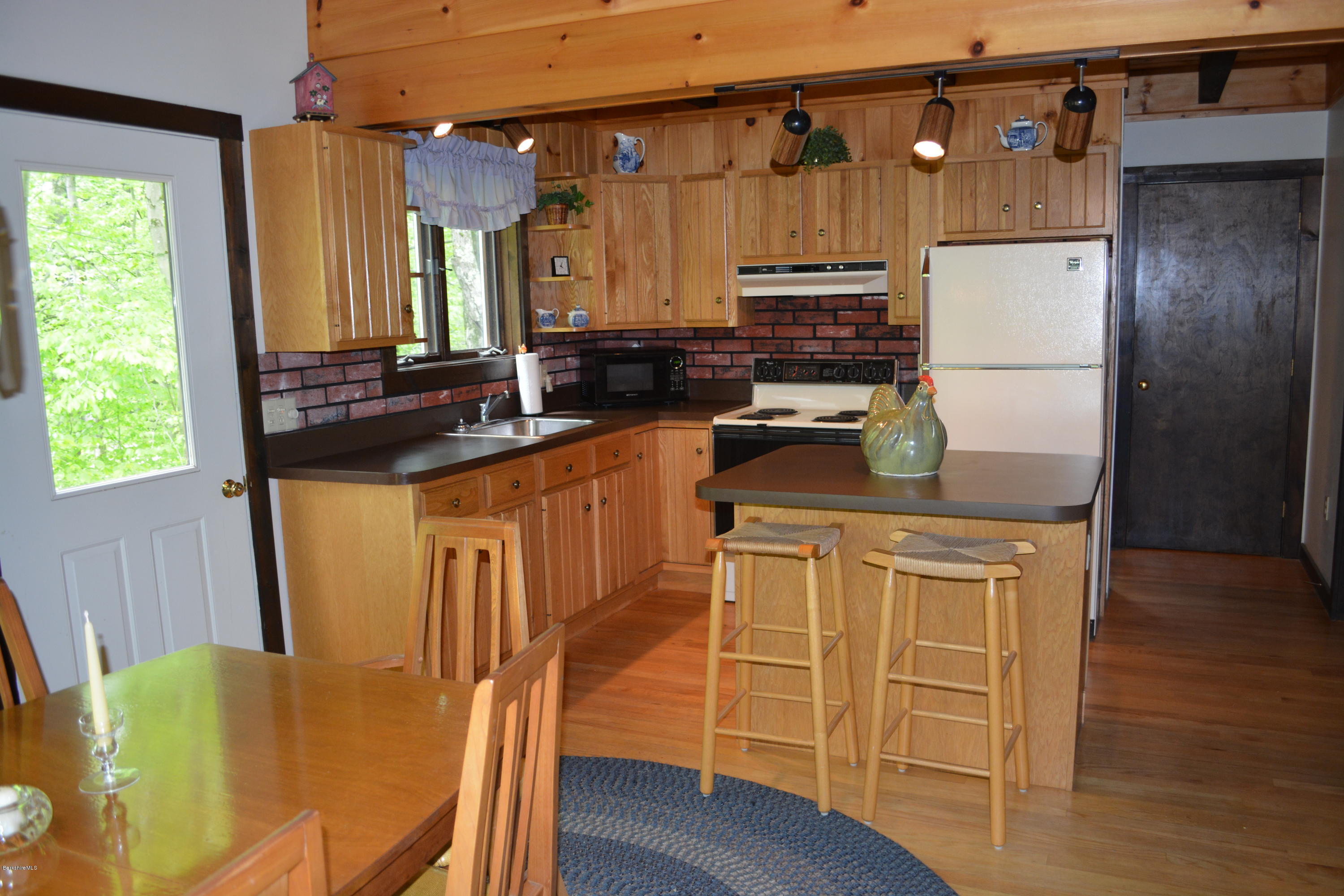 56 Slope Road Tolland, MA 01034 - Photo 34 of 52 a kitchen with stainless steel appliances granite countertop a refrigerator a stove a sink dishwasher and microwave with wooden floor