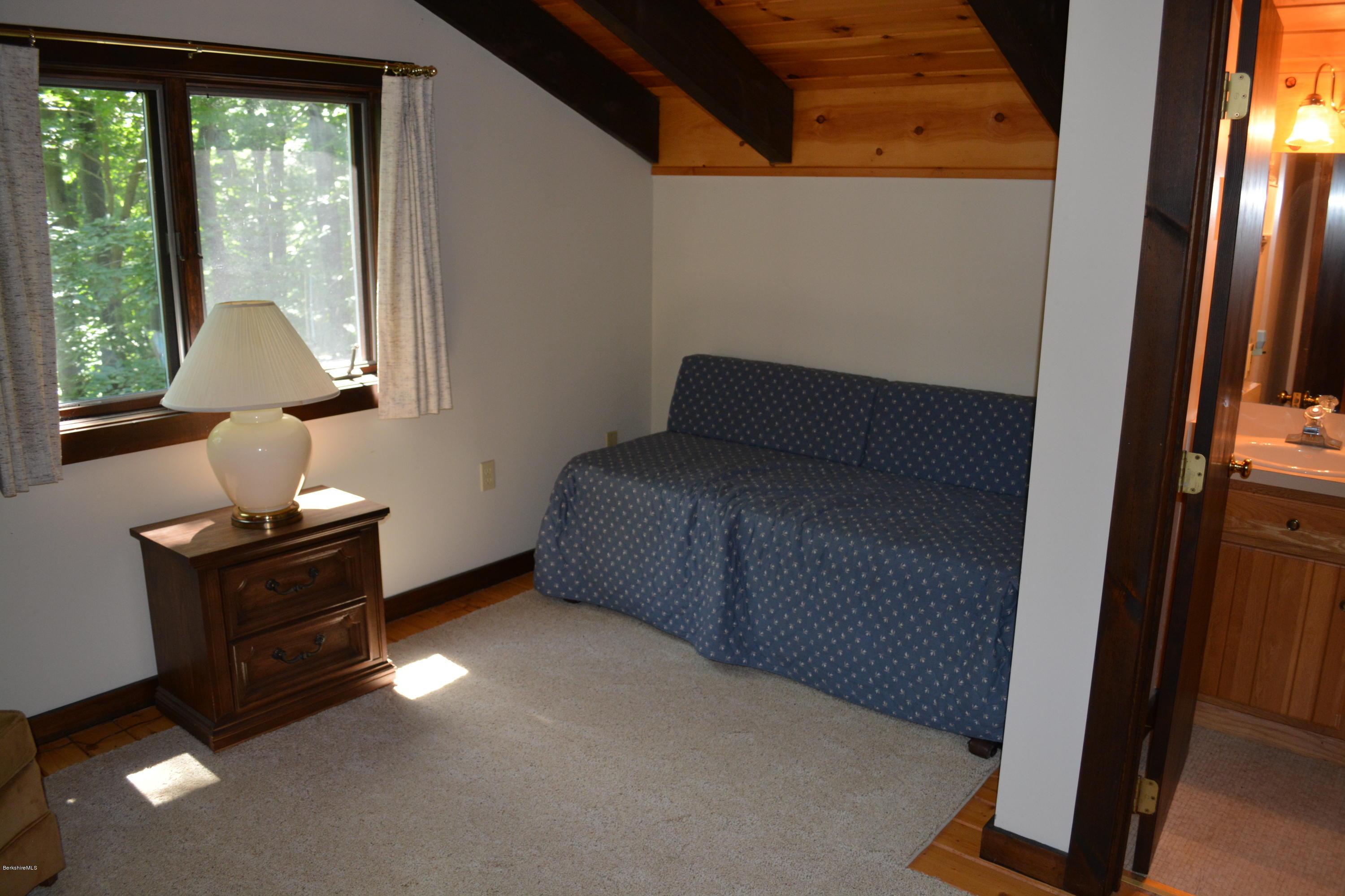 56 Slope Road Tolland, MA 01034 - Photo 37 of 52 a bed room with a bed and a lamp on table