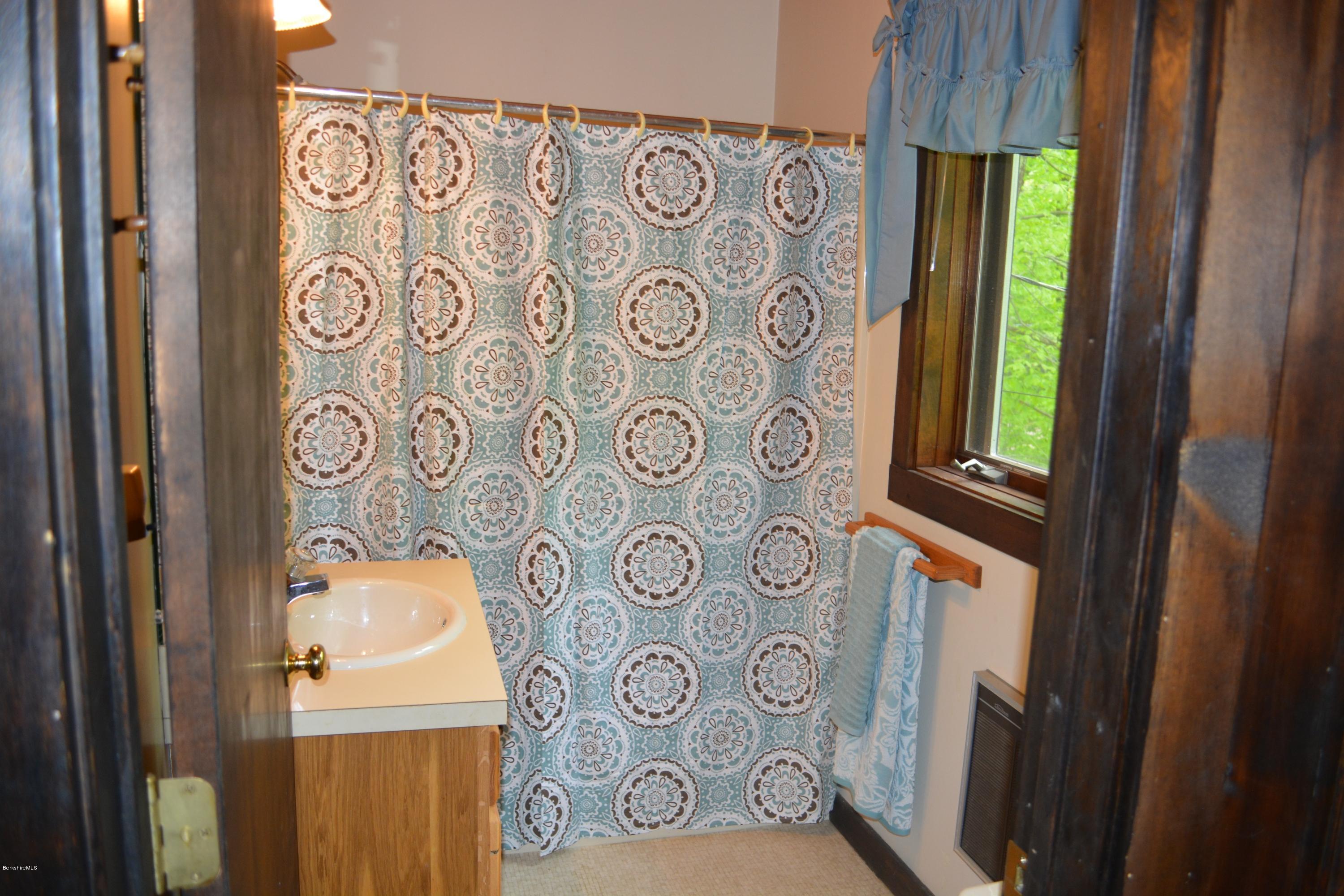 56 Slope Road Tolland, MA 01034 - Photo 50 of 52 a bathroom with a toilet and a shower curtain