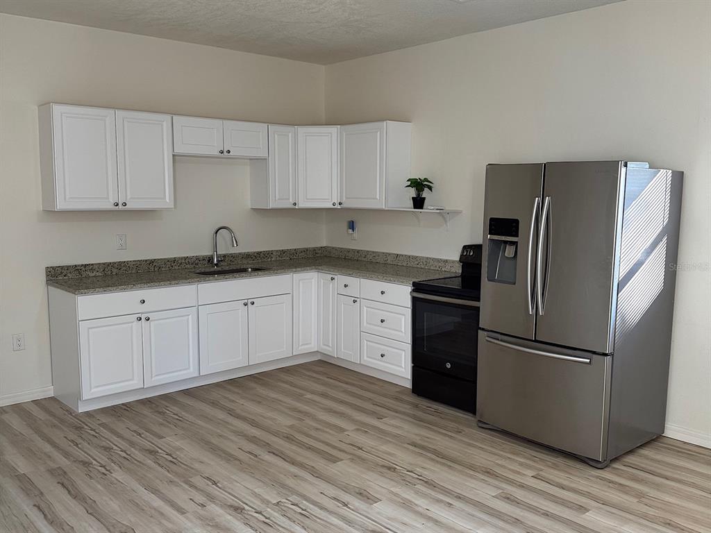 623 Beckett Way, Unit A Tarpon Springs, FL 34689 - Photo 2 of 19 a kitchen with a refrigerator sink and cabinets