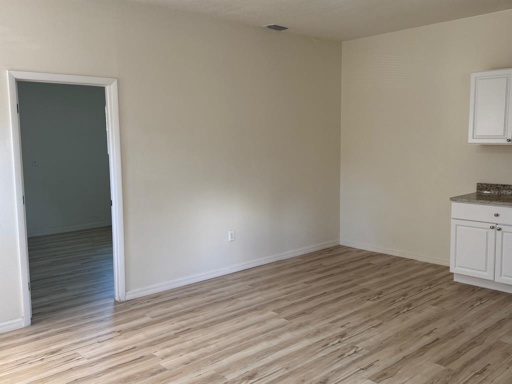 623 Beckett Way, Unit A Tarpon Springs, FL 34689 - Photo 3 of 19 wooden floor in a hall with an empty room