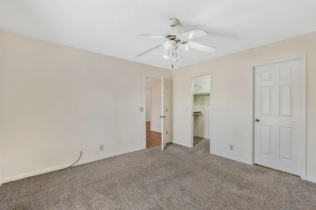 a view of an empty room with a chandelier fan