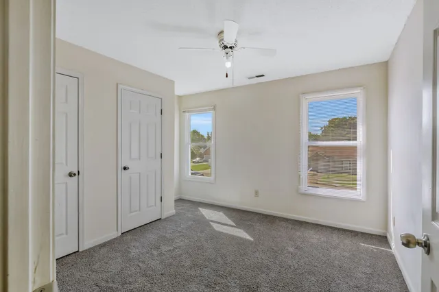 an empty room with windows and closet
