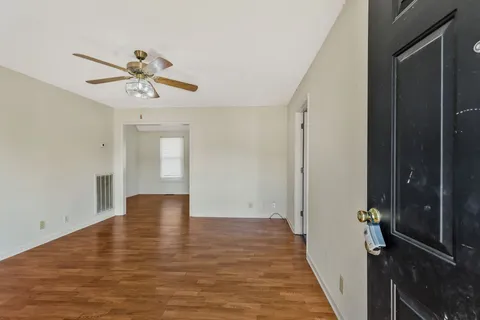 a view of room with hardwood floor and ceiling fan