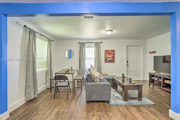 a living room with furniture and wooden floor