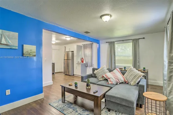 a living room with furniture and a wooden floor