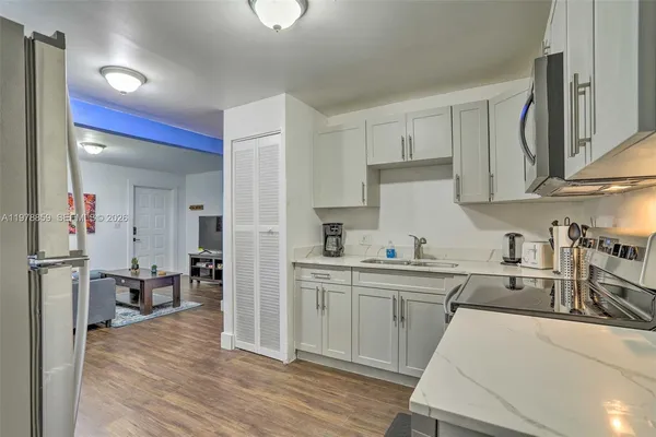 a kitchen with a sink cabinets and wooden floor