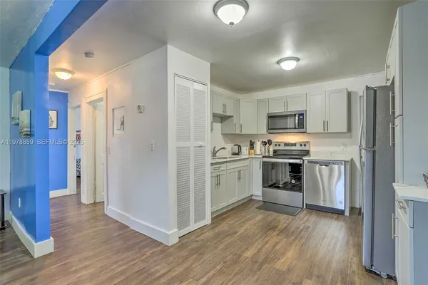 a kitchen with white cabinets and stainless steel appliances