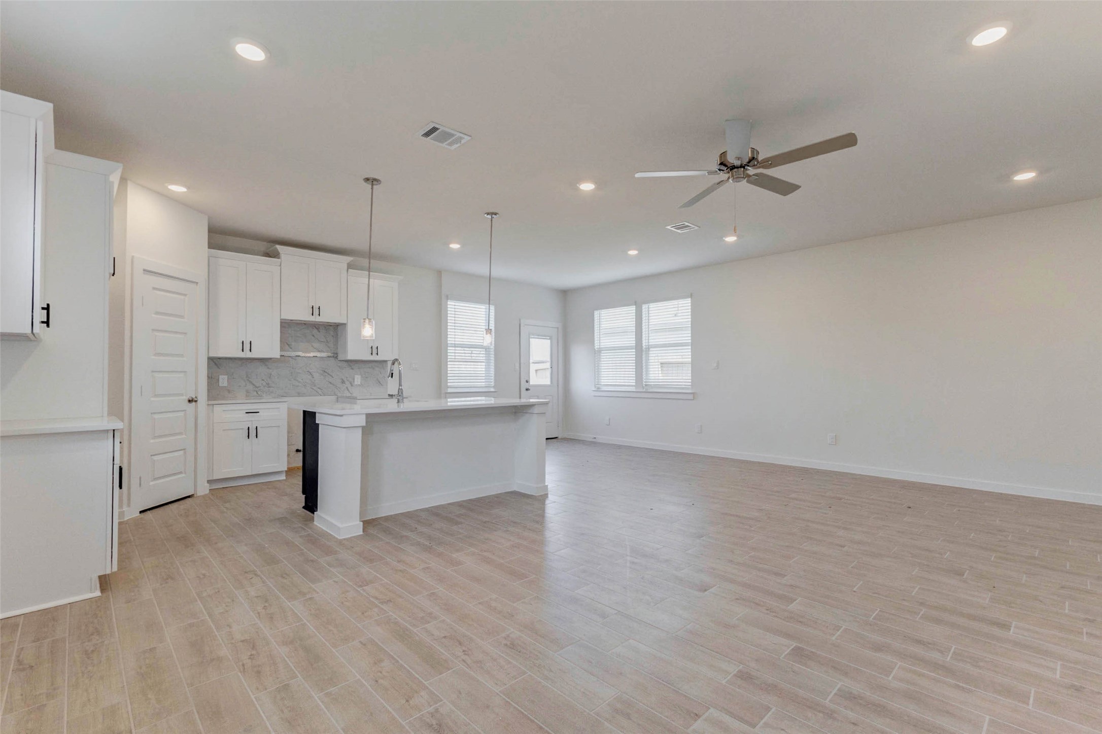 1131 Santee Court Rosharon, TX 77583 - Photo 12 of 31 Abundant natural light streams in through oversized windows, brightening the large kitchen and dining space. The layout provides flexibility for various furniture arrangements, with easy access to the backyard through the rear door.